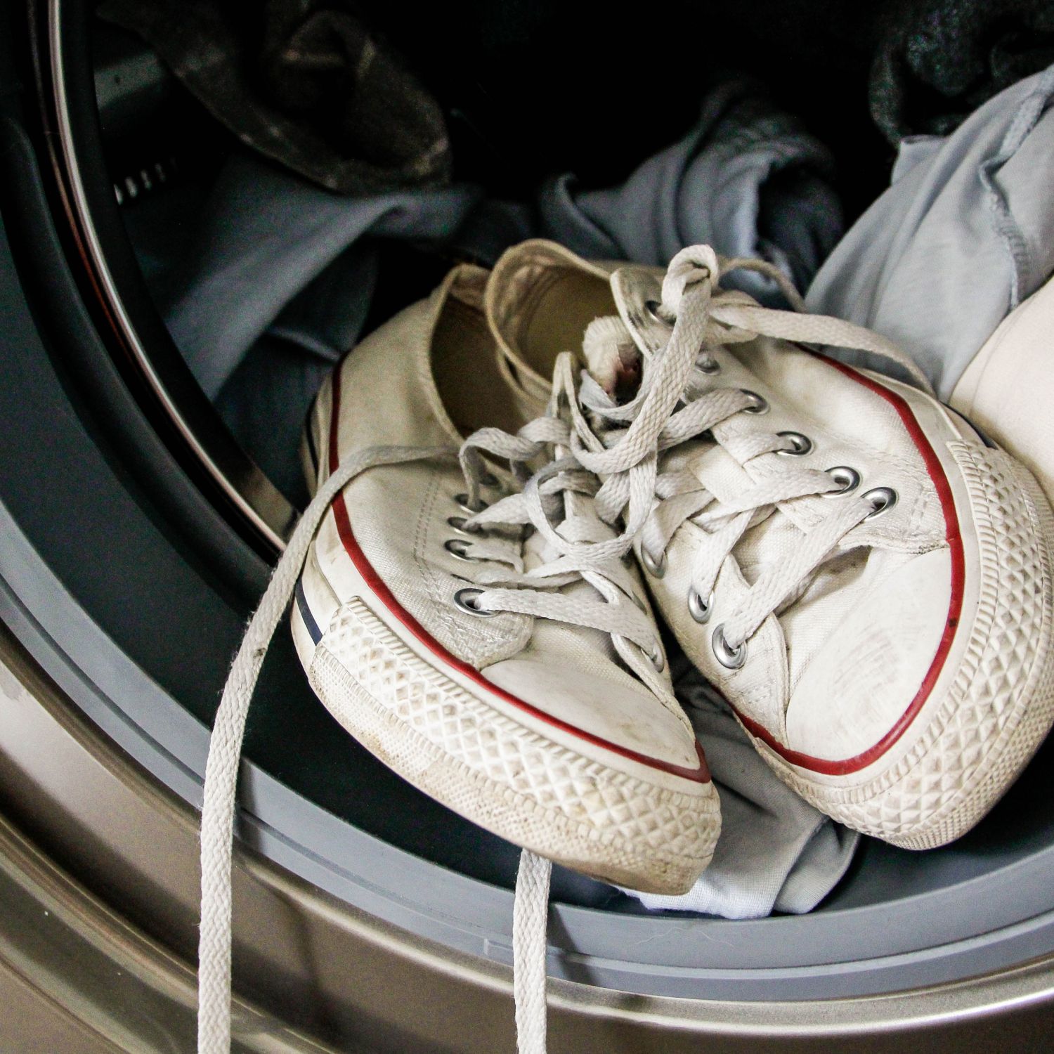 wash just about anything image of dirty white sneakers and t-shirts in a front load washing machine