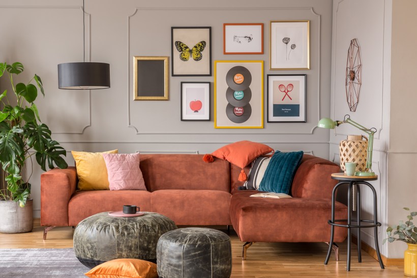 vintage black poufs in trendy living room with copper brown velvet couch has colorful pillows eclectic decor