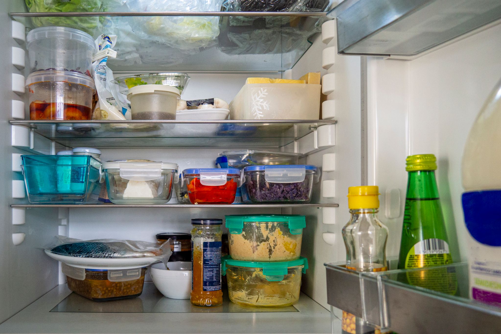 organized refrigerator open fridge with leftover food in glass containers other groceries