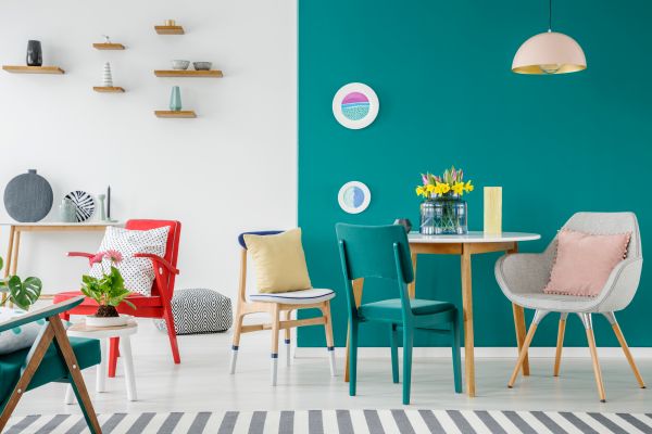 diy make house a home colorful chairs at wooden tables against green wall in apartment interior with flowers