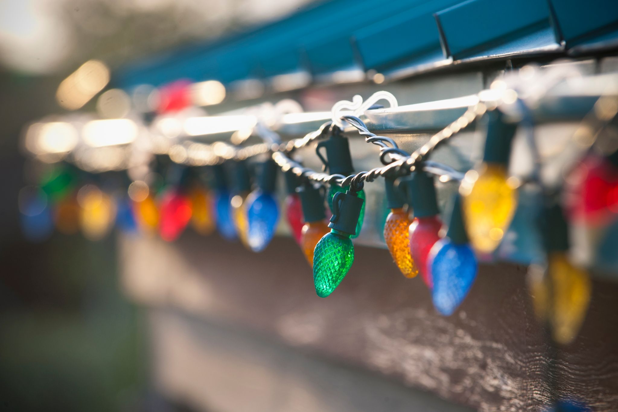 know about solar christmas lights multi colored large bulb lights hanging on a roof edge in low winter light