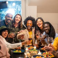 A group of friends taking a selfie at dinner party toasting the celebration with holiday vibes.