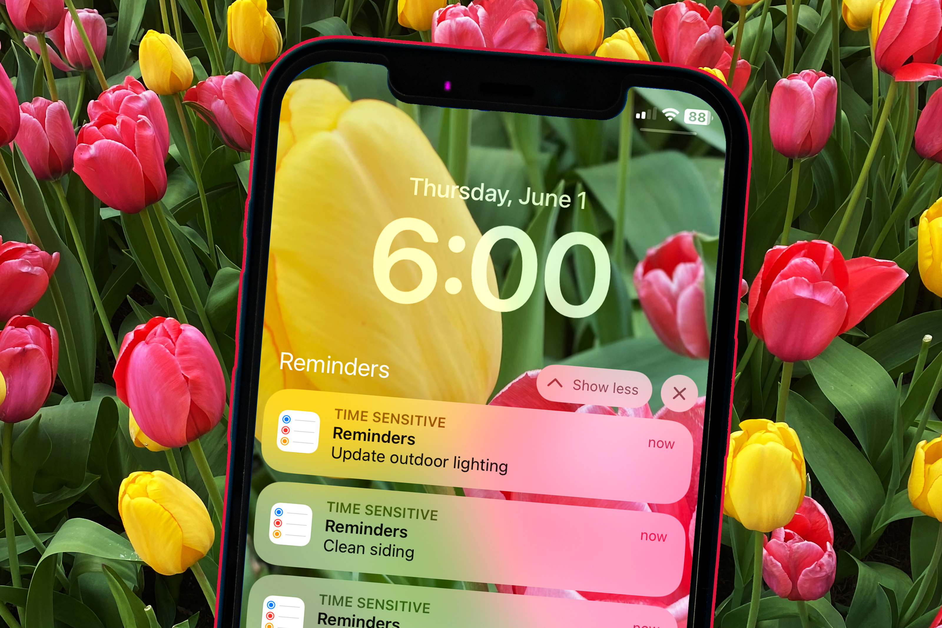 cell phone reminder of home maintenance tasks to complete now in june with a background of pink and yellow tulips
