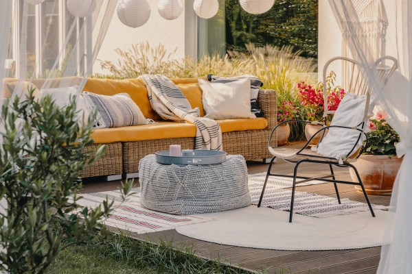 easy yard upgrade photo wicker couch bright pillows, blankets, a chair, soft curtains, lights on patio