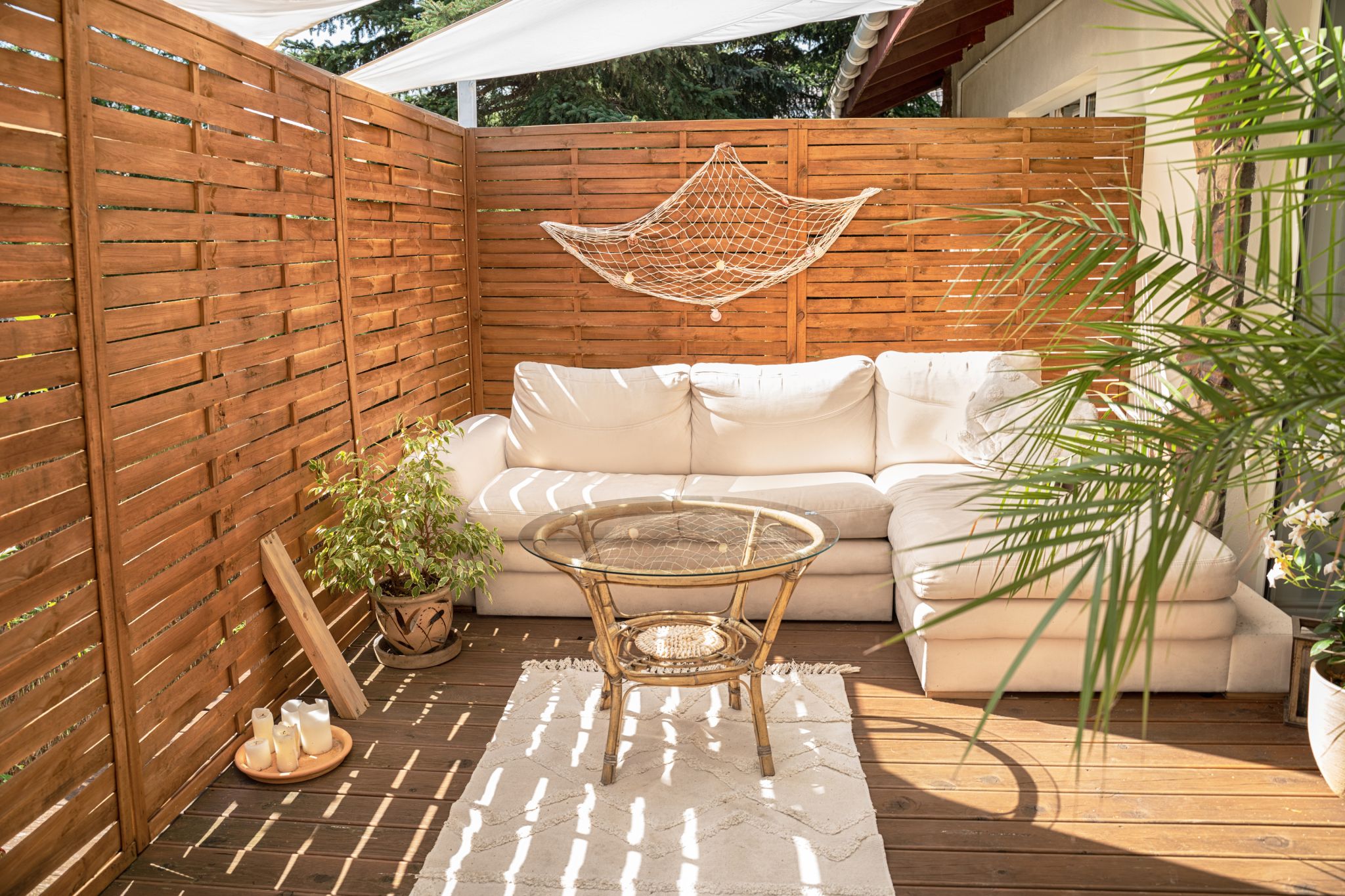 backyard problem solutions photo of patio with wooden privacy fence, comfy furniture and green plants