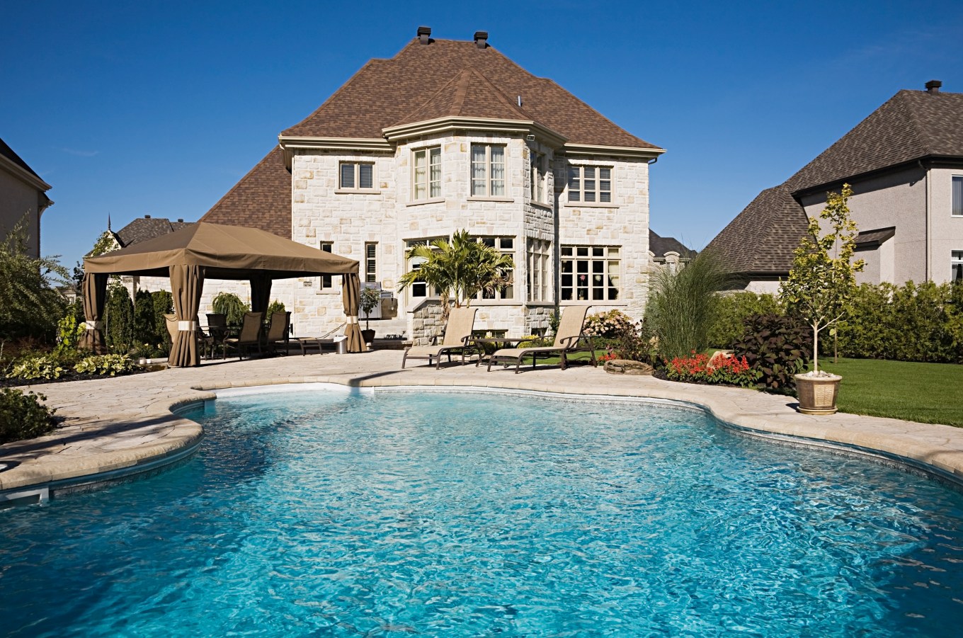 Safe alternatives to chlorine swimming pools image of inground pool in backyard of large home