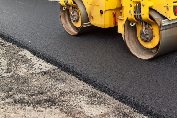 New asphalt road being paved. Road asphalt cost.