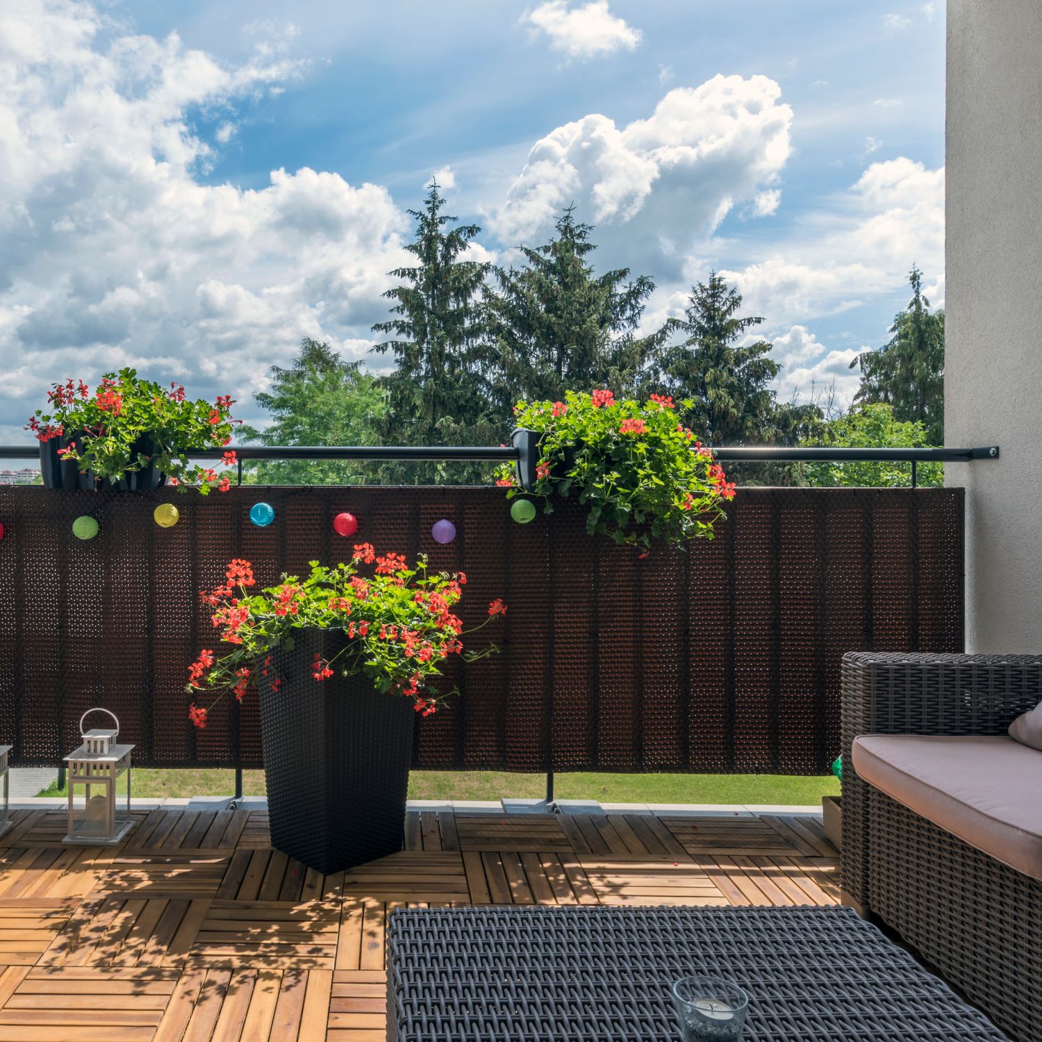 A home terrace with a wooden floor, a sofa, and a relaxed, open area is a practical backyard patio idea.