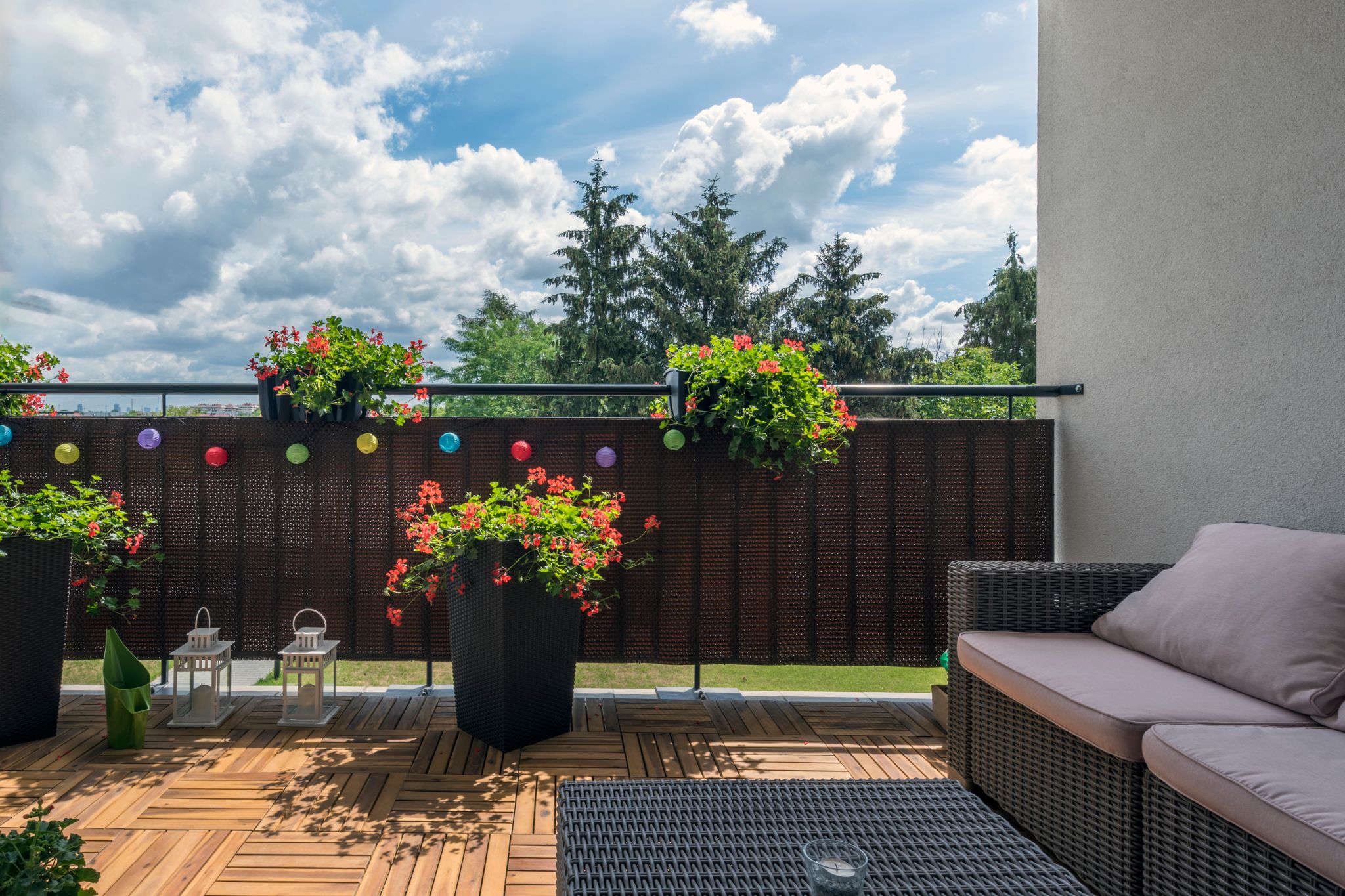 A home terrace with a wooden floor, a sofa, and a relaxed, open area is a practical backyard patio idea.