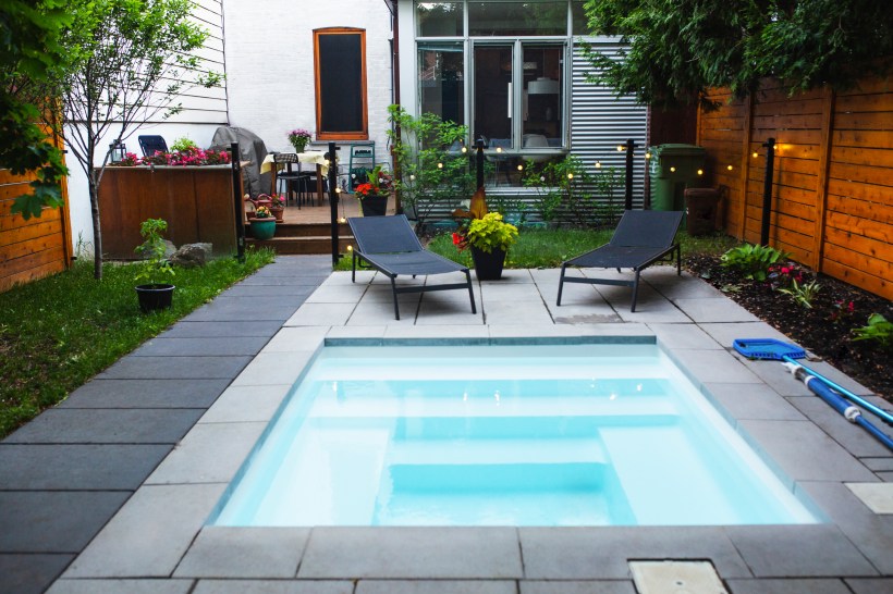 A small, rectangular swimming pool in the backyard.