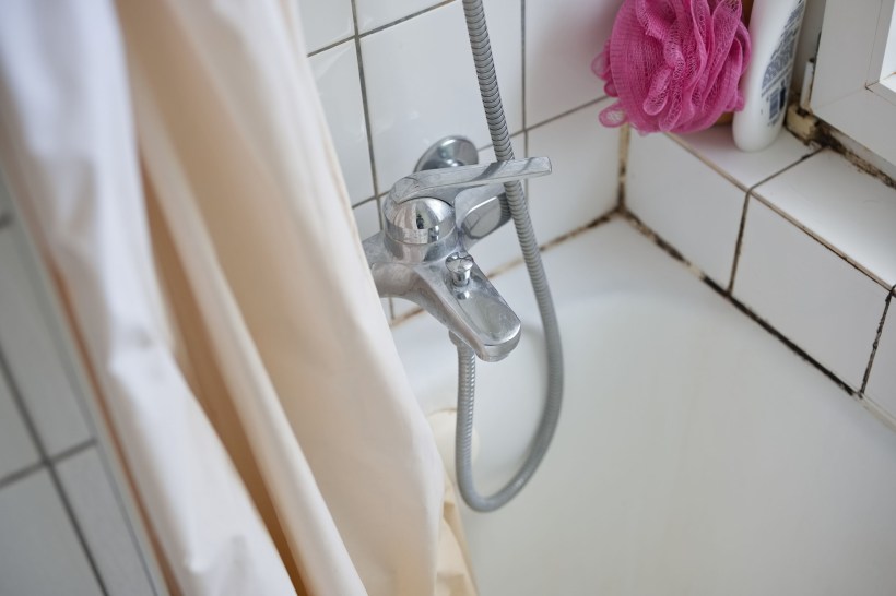 Close-up shot of an unclean bathtub with visible dirt and grime that could be refinished.