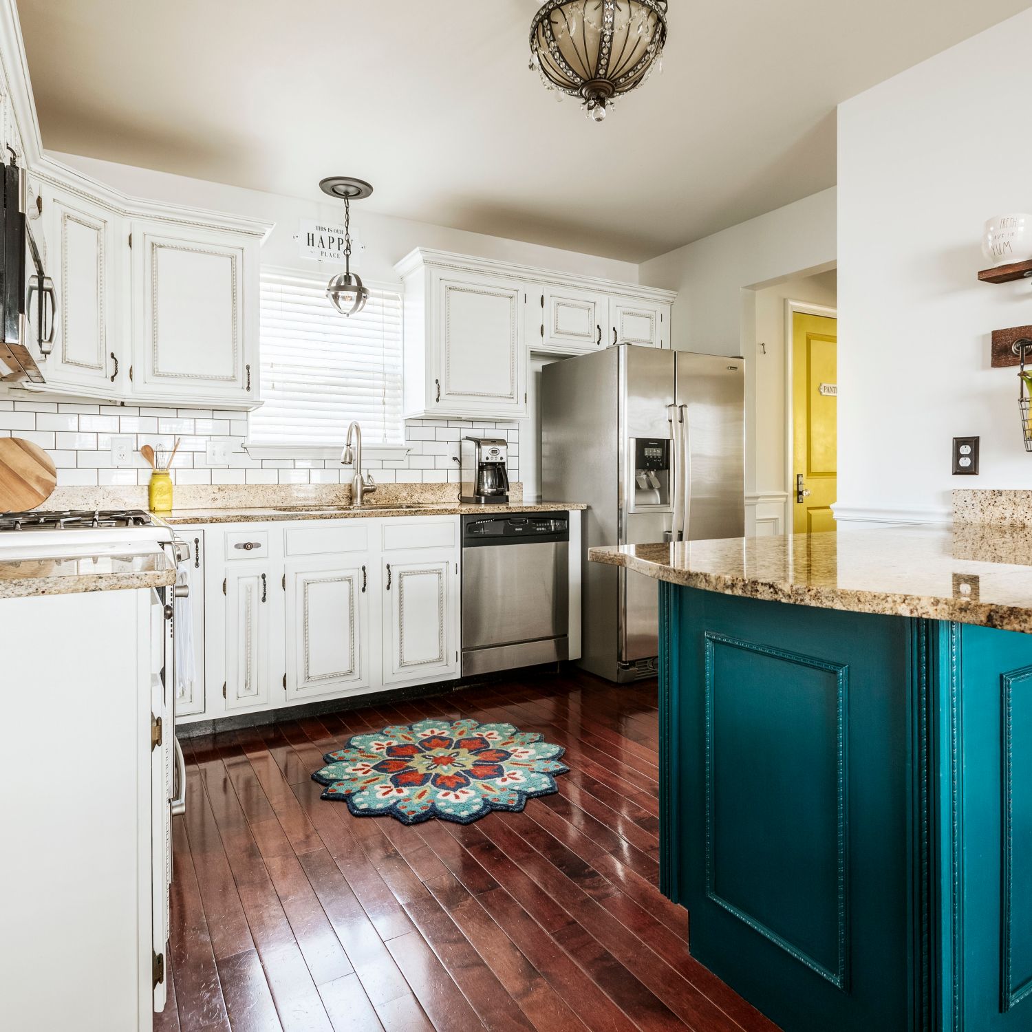 White kitchen with a pop of color on the pantry door and island counter.