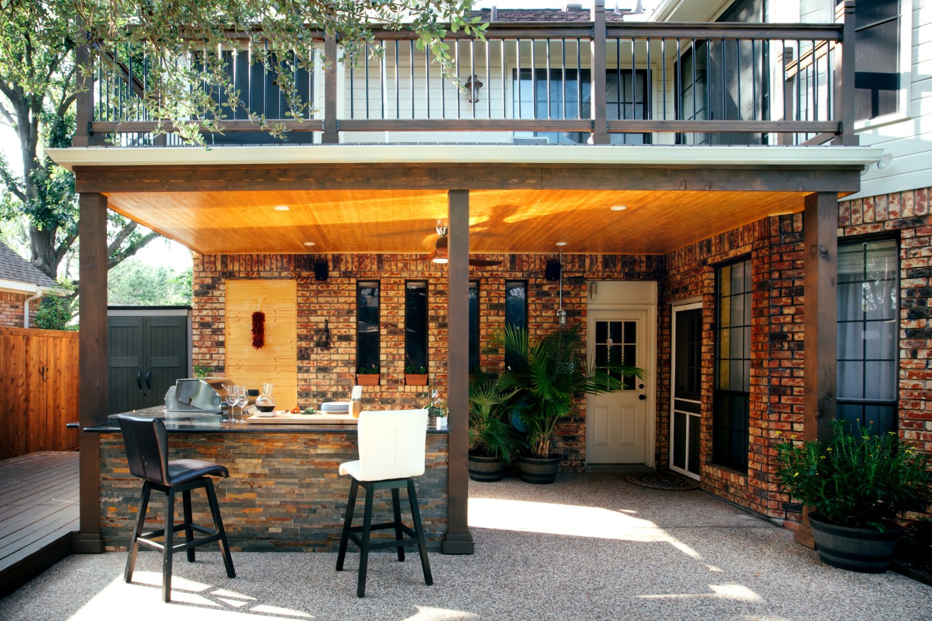 New and modern outdoor kitchen on a sunny summer evening under the cover of a balcony.