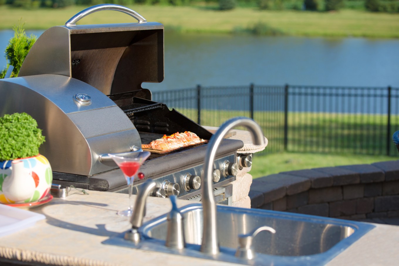 Salmon being cooked on a stainless steel grill, an example of the kind of durable material you need for an outdoor kitchen.