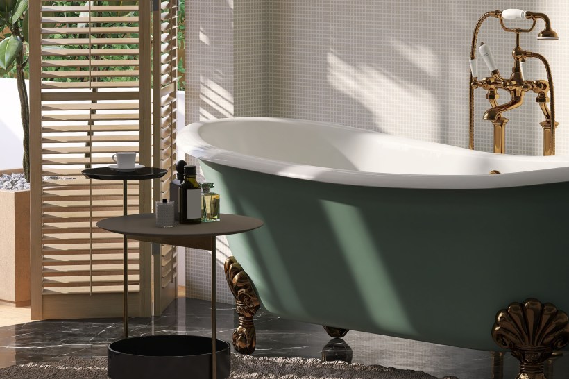 A green cast iron claw-foot bathtub in a luxury bathroom with sunlight from window blinds.
