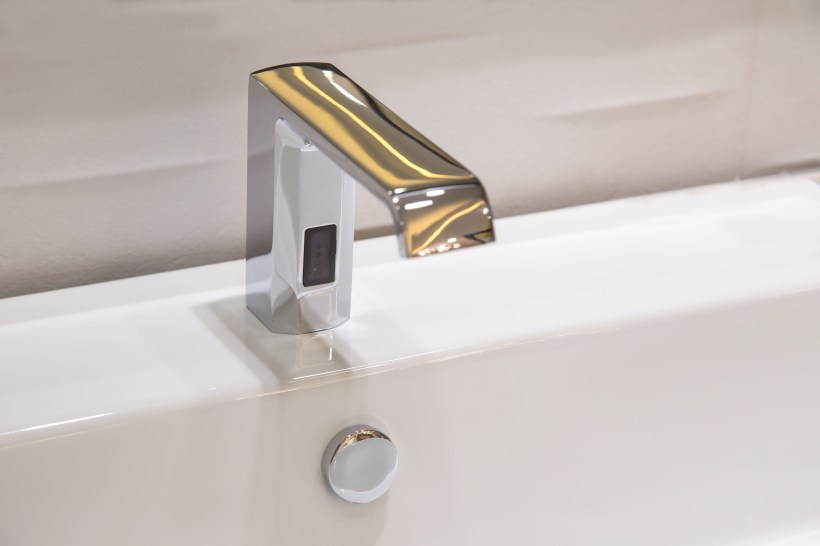 Touchless bathroom faucet in polished chrome powered by a sensor.