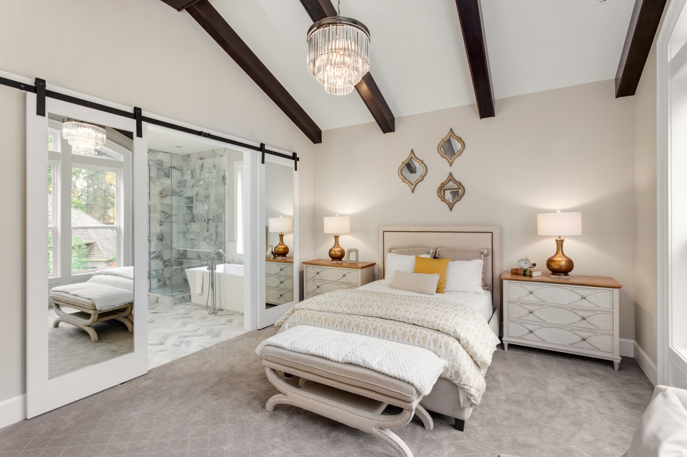 Barn door style opening to a bathroom in a master bedroom.