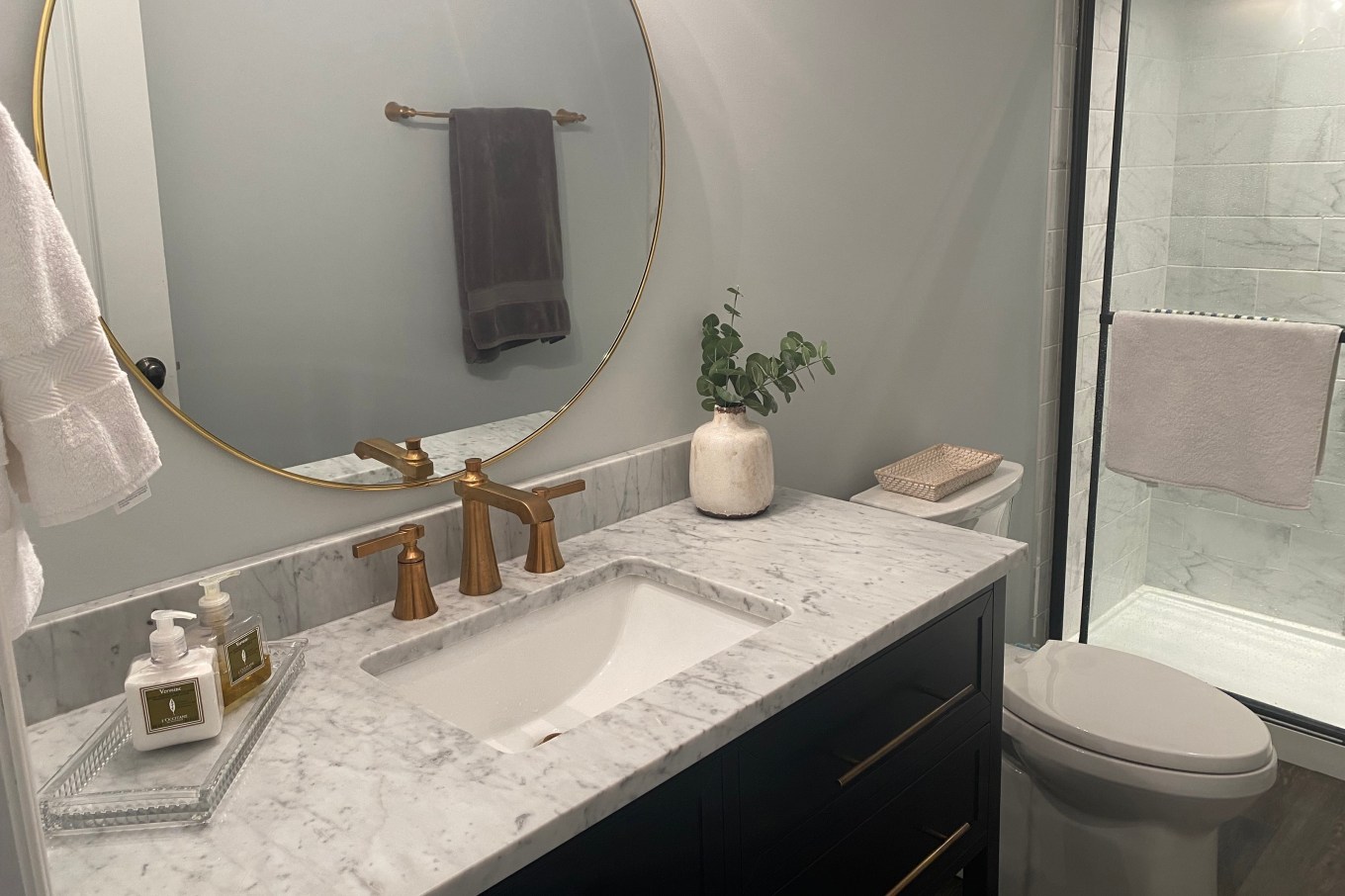 A remodeled bathroom featuring calm colored walls and a sink.