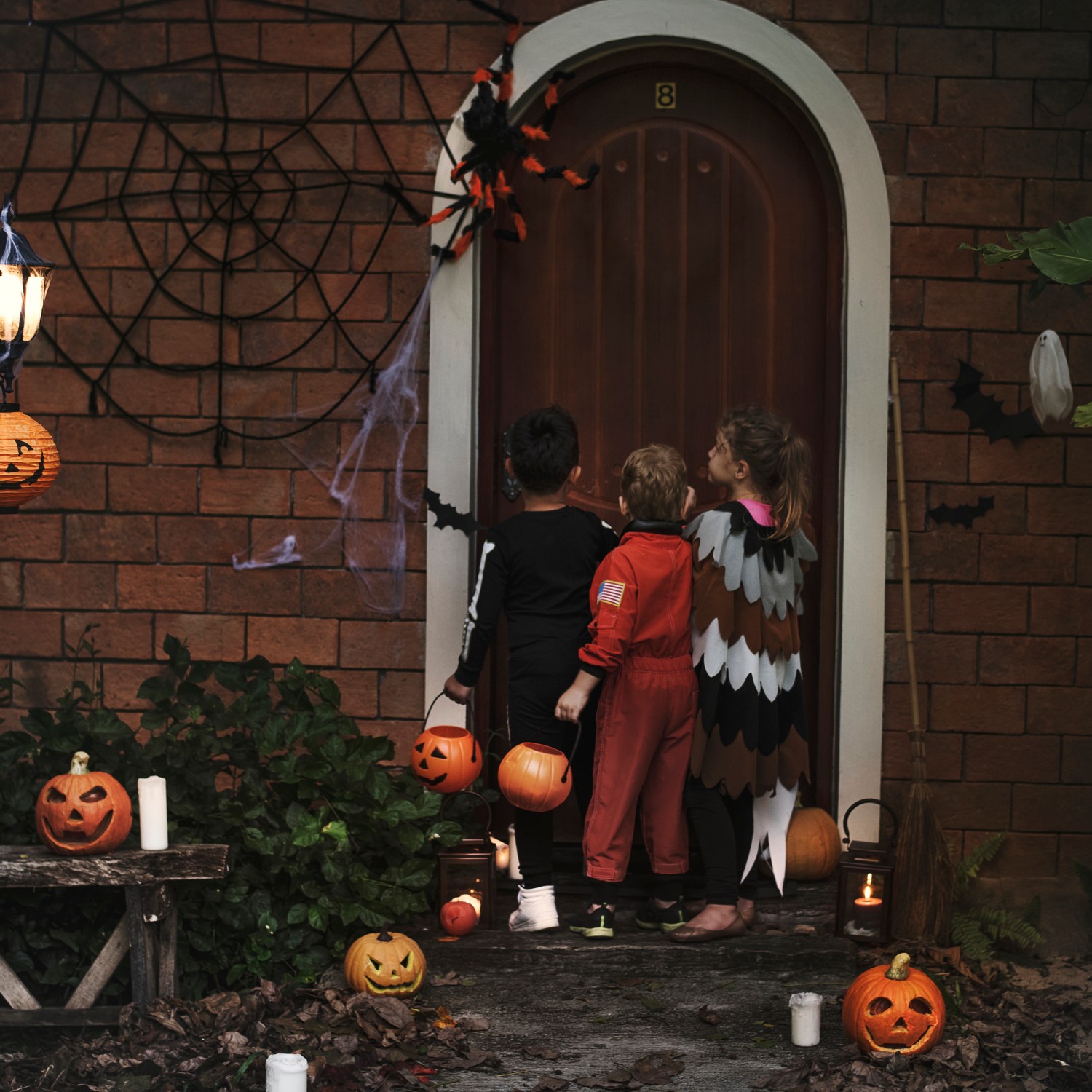 A group of young children at a door, trick or treating on Halloween