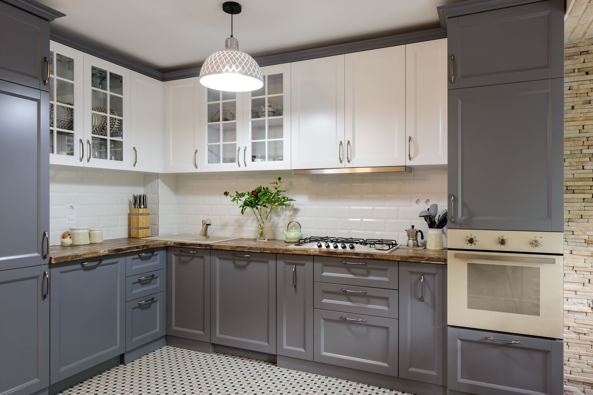 A modern, luxury remodeled kitchen with grey and white cabinets.