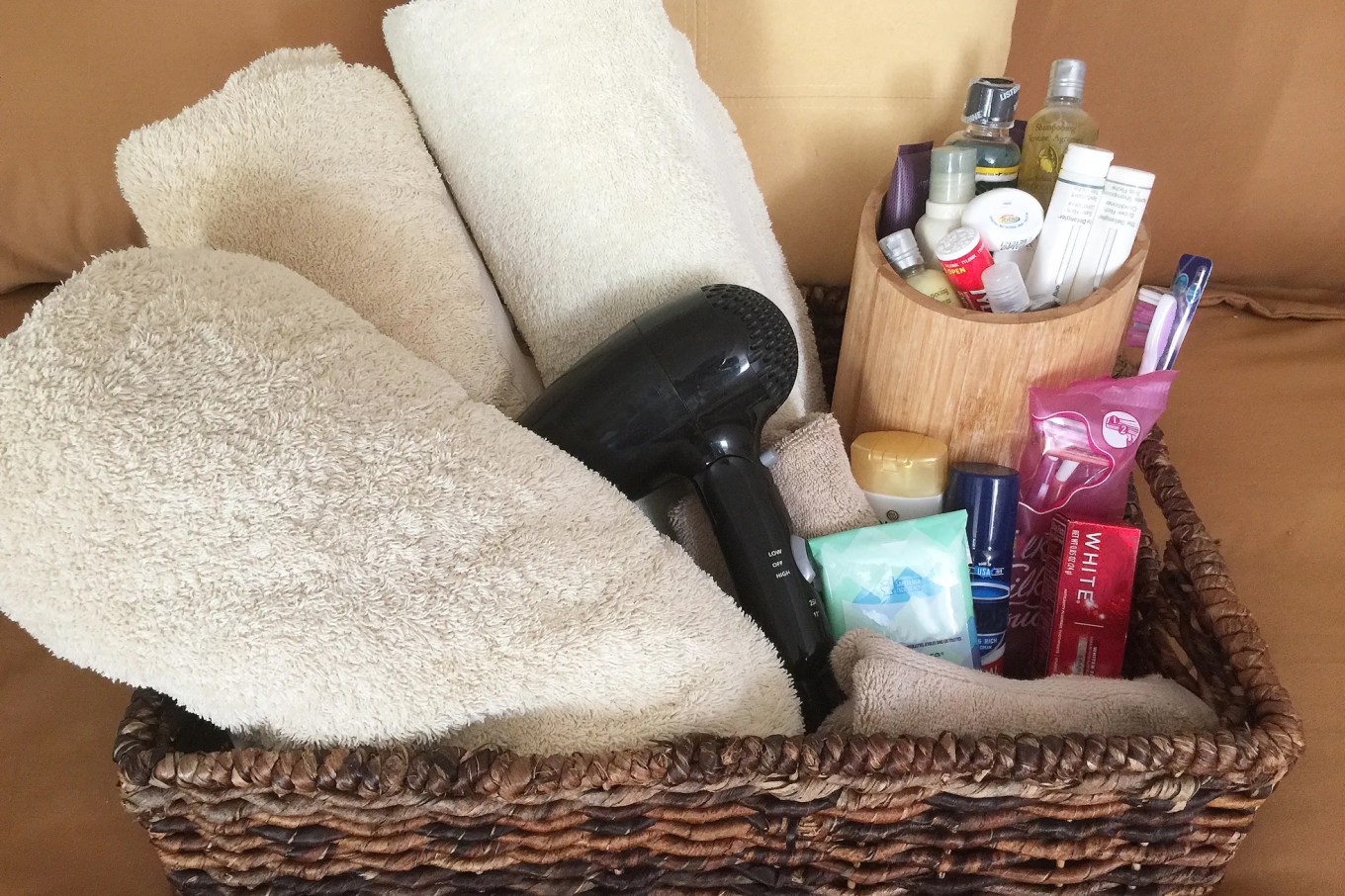 A basket filled with white towels and mini toiletries