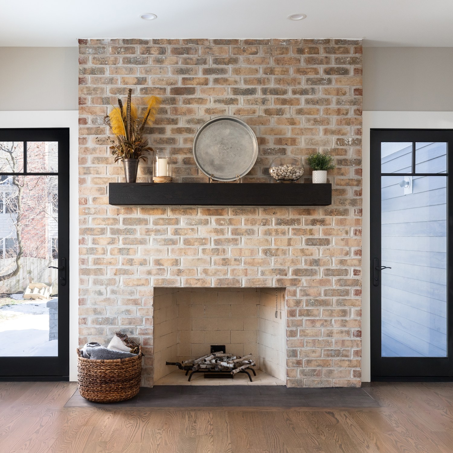 A beautiful, cozy fireplace with natural brick and a wood mantle shows a fireplace that's an option for painting.