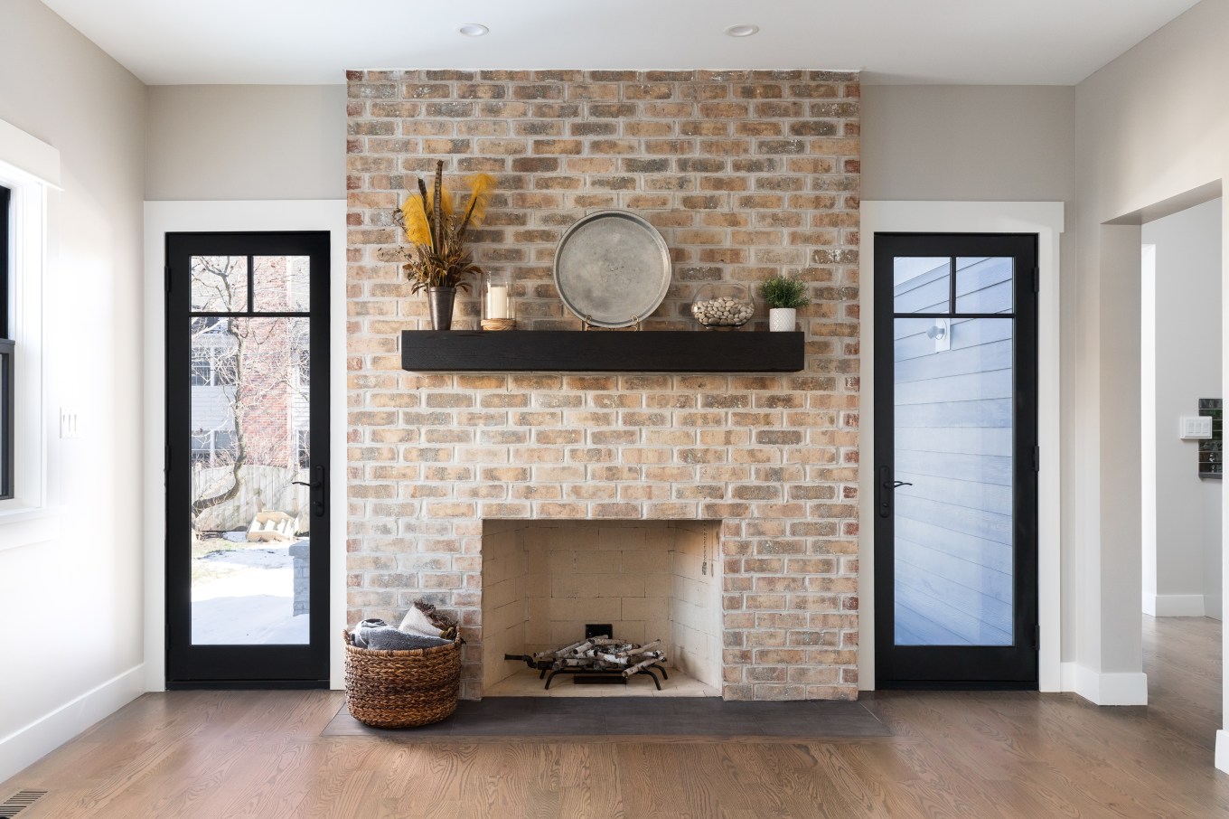 A beautiful, cozy fireplace with natural brick and a wood mantle shows a fireplace that's an option for painting.