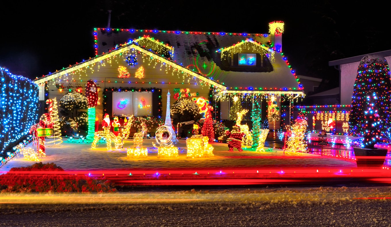 A beautifully decorated house with lots of Christmas lights and lawn ornaments is an example of a house decorated in the maximalist style.