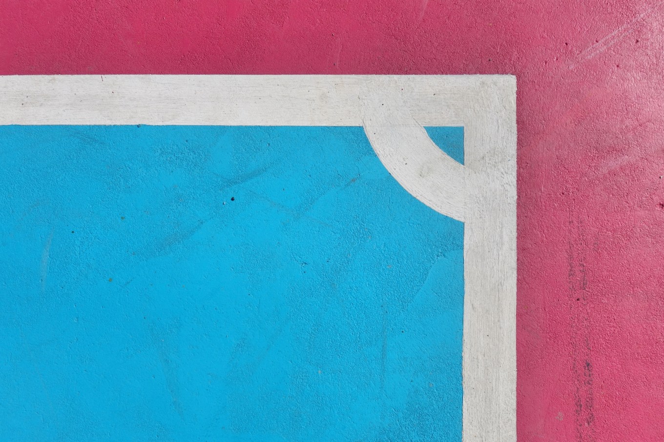 Painted concrete floor of a patio with red, white, and blue in a specific pattern.