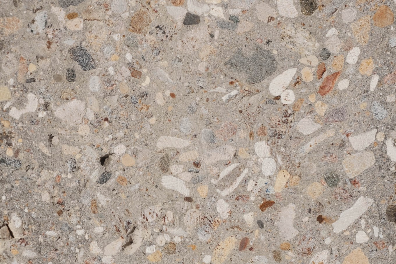 Grinded concrete textured with pebbles and small gravel stones.
