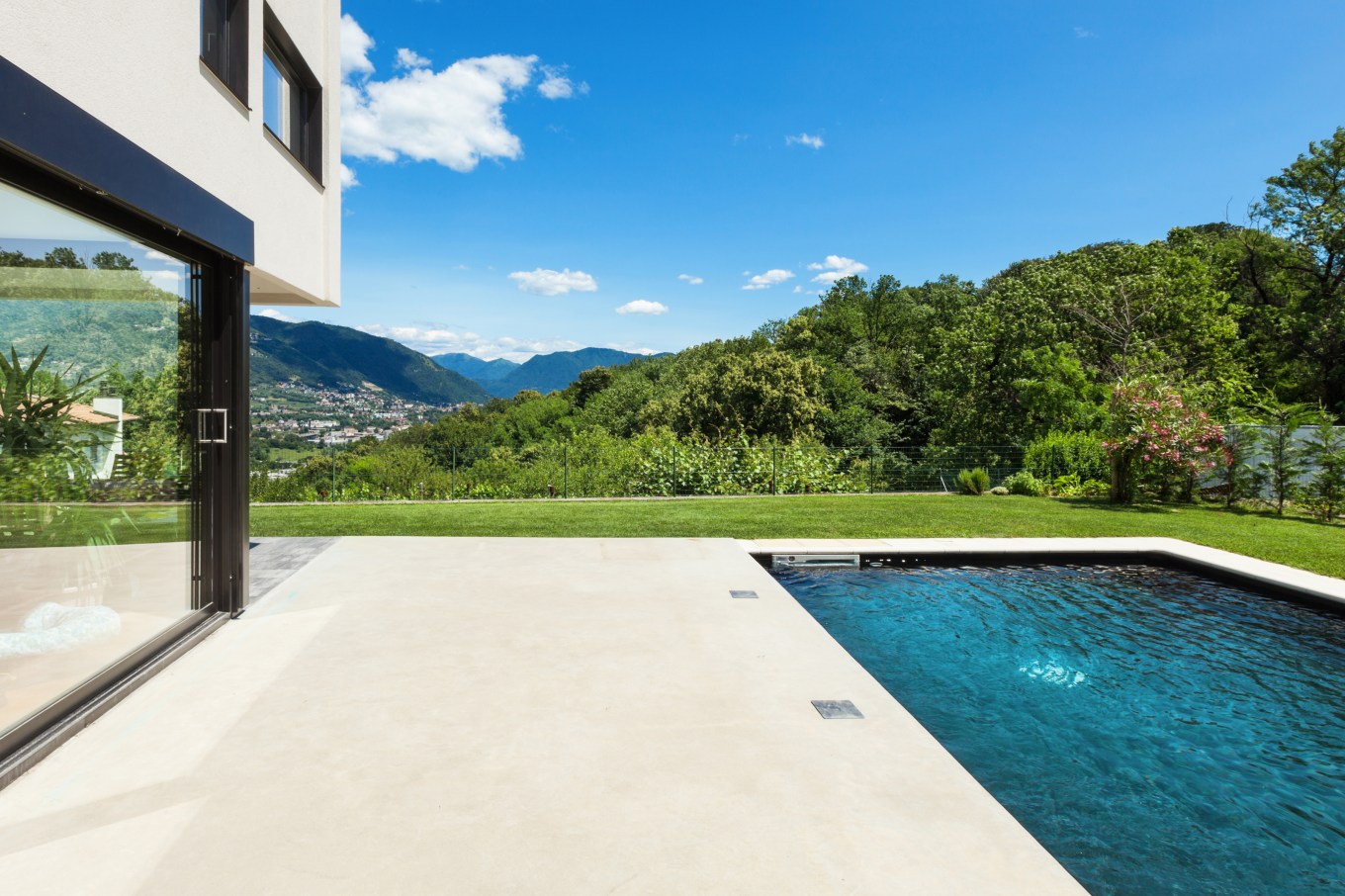 Polished concrete patio extending out to a backyard pool.