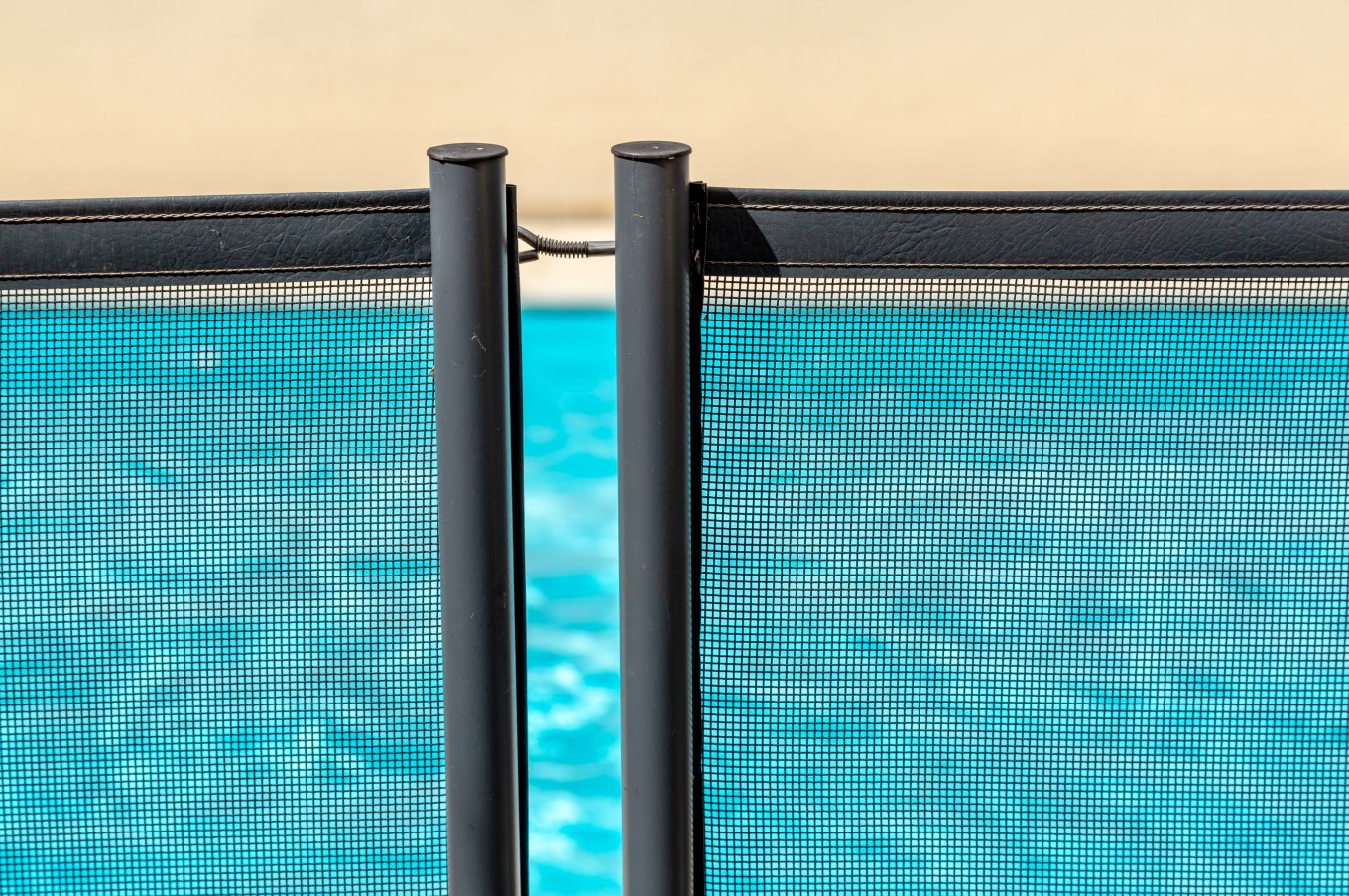 View of a pool through a dark, mesh safety net.