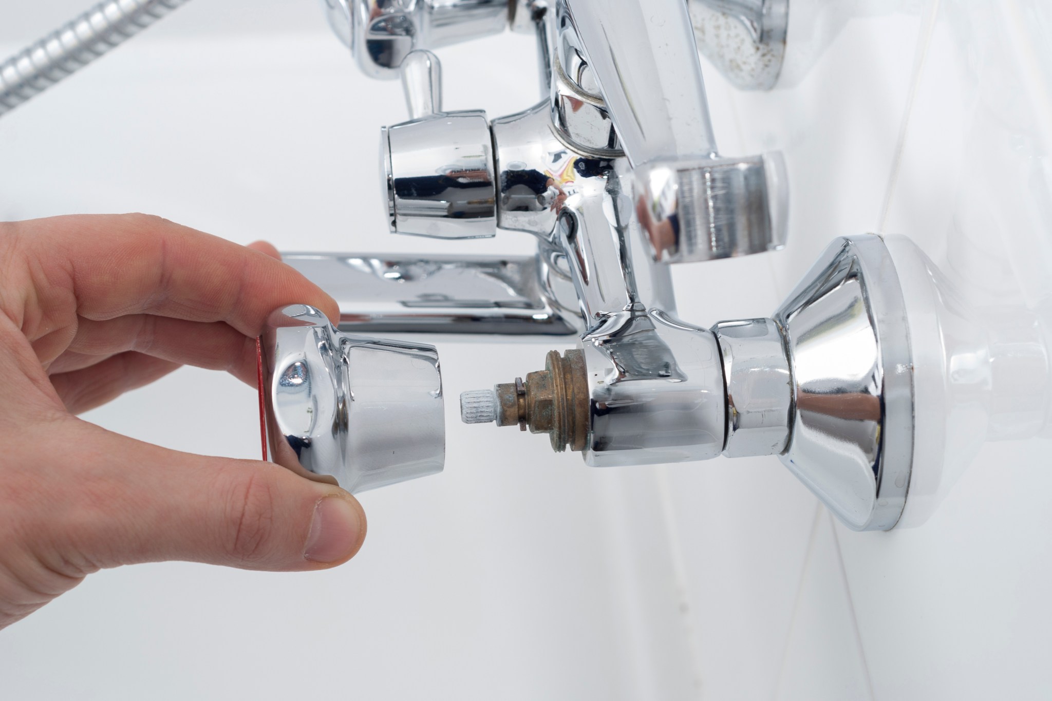 A faucet in a white bathtub being repaired as part of a shower head or shower valve replacement.