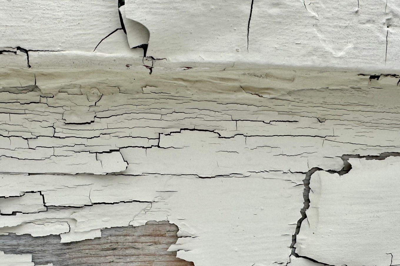 Cracked, chipping paint on a wall that will need careful removing.