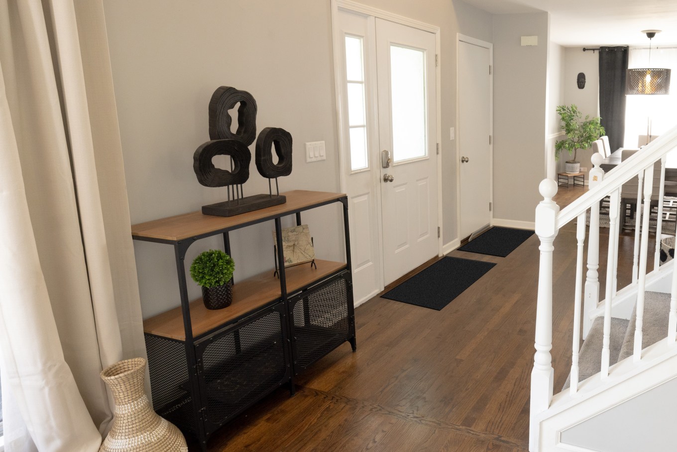 A hidden shoe rack next to a front door and garage door with doormats.