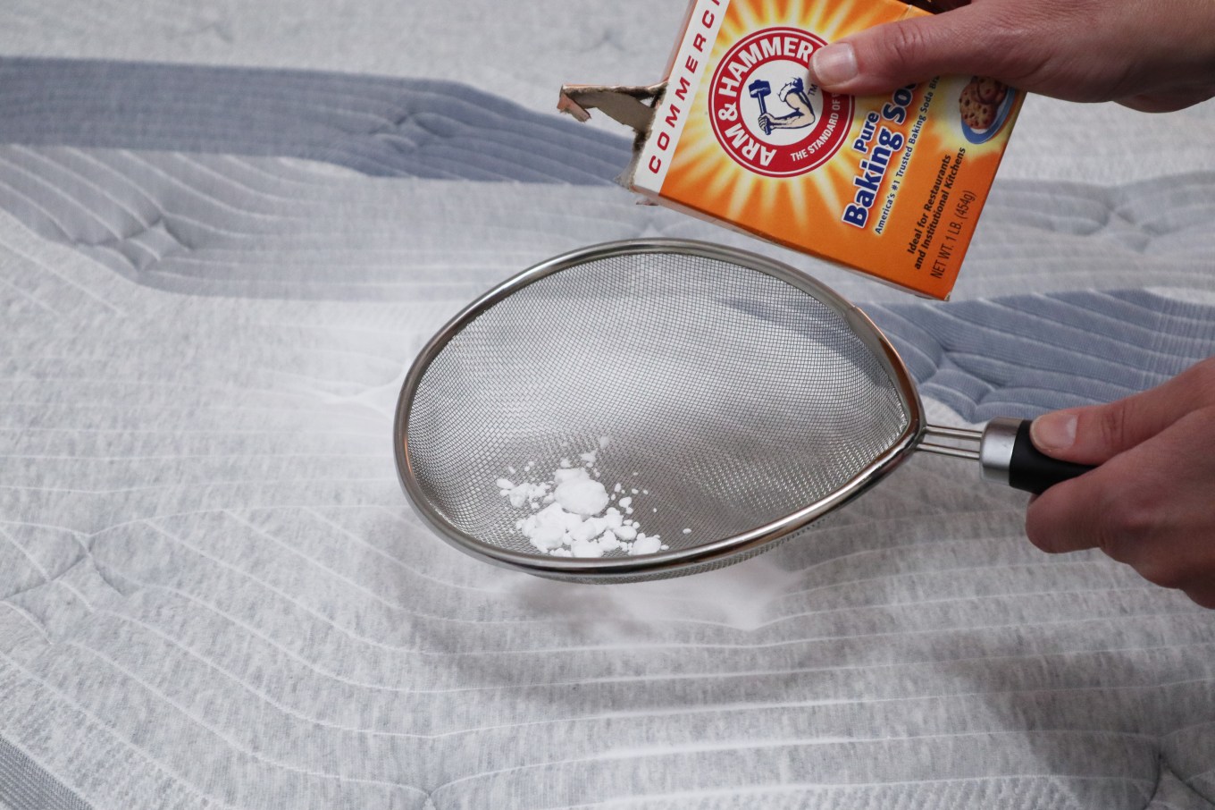 A bed being cleaned with baking soda in a sifter.