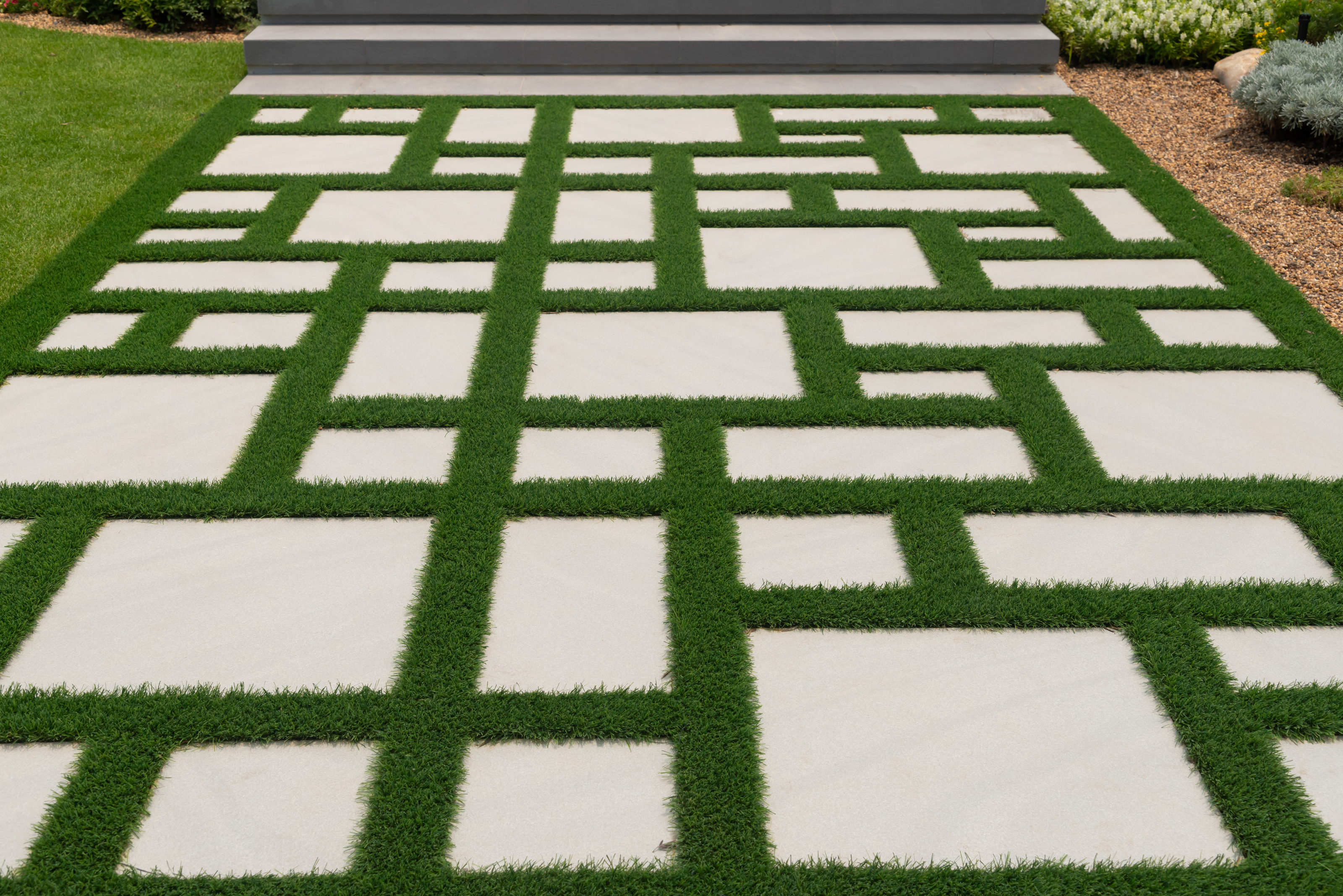 Texture or pattern of paving walkway with green grass.