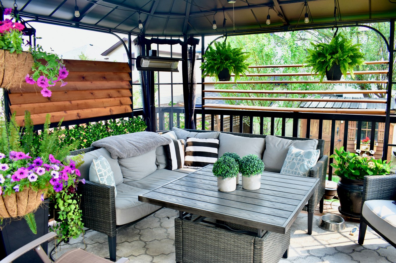 A suburban deck with a roof and movable wooden shades.