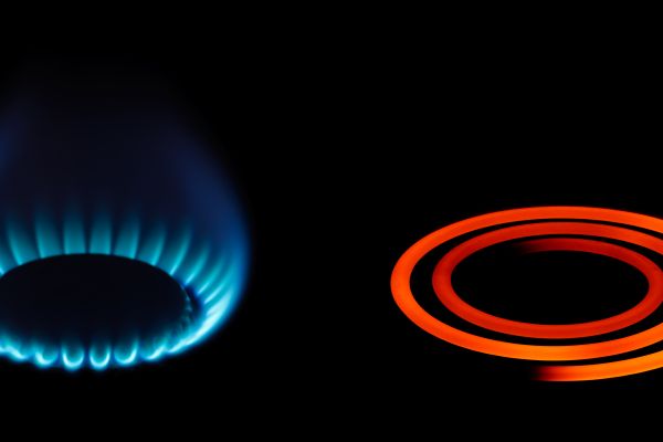A gas stove and electric stove cooker ring on full power.