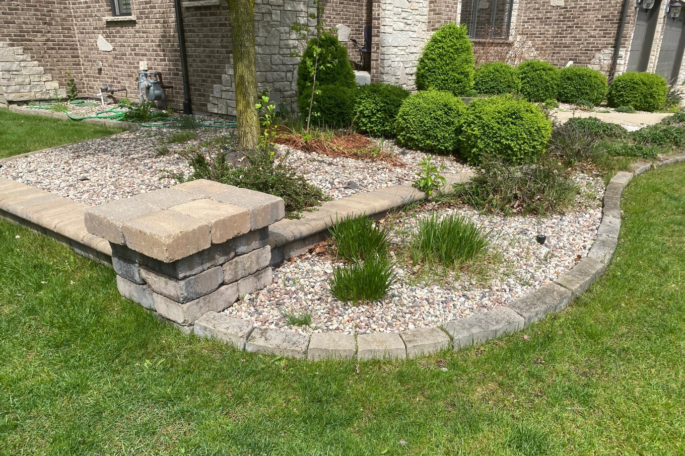 Edging of stone that separates the yard here from the shrubbery.