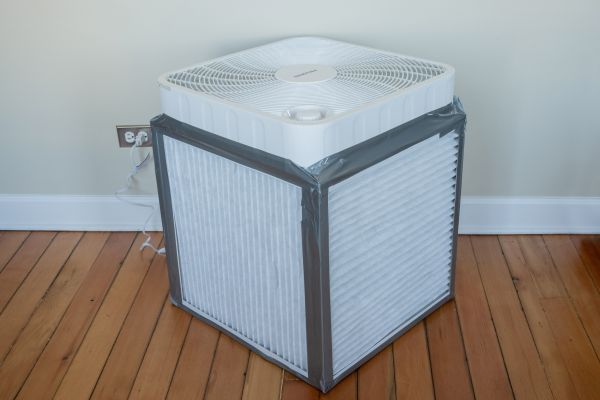 Step 4. Place your fan on the top of the cube so that the air is blowing up and the cord is going down through the cube. Step 5. Tape the fan onto the cube.