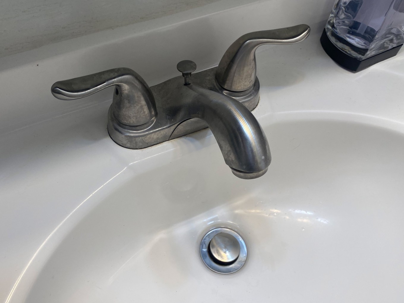 A faucet and sink drain in a bathroom.