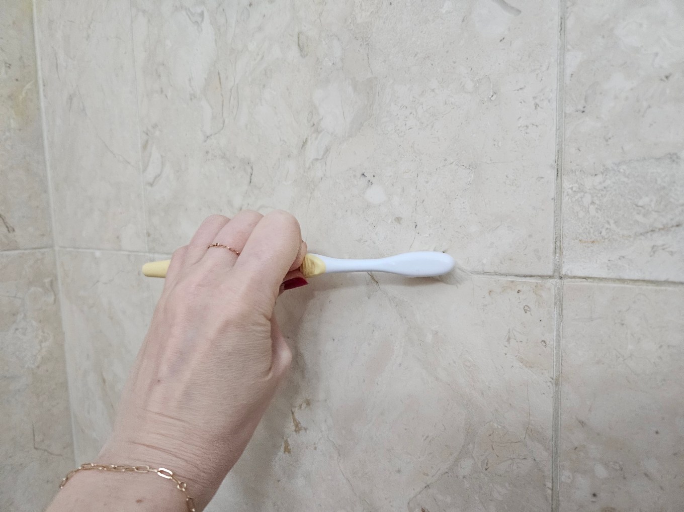 Scrubbing the grout in the bathroom.
