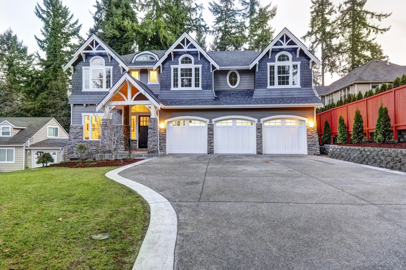 A luxurious home exterior with blue vinyl siding and white trim and three attached garage spaces. This is an example of a good home for co-ownership