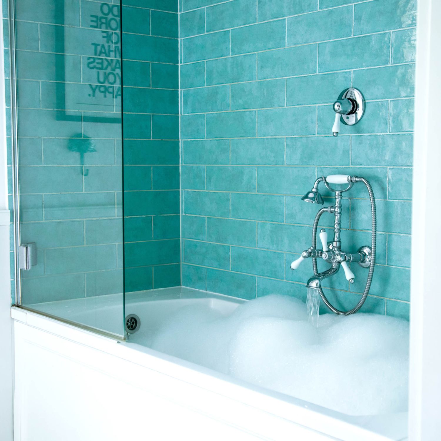 A classic bathtub with tiling on the wall showing what might be replacing showers.