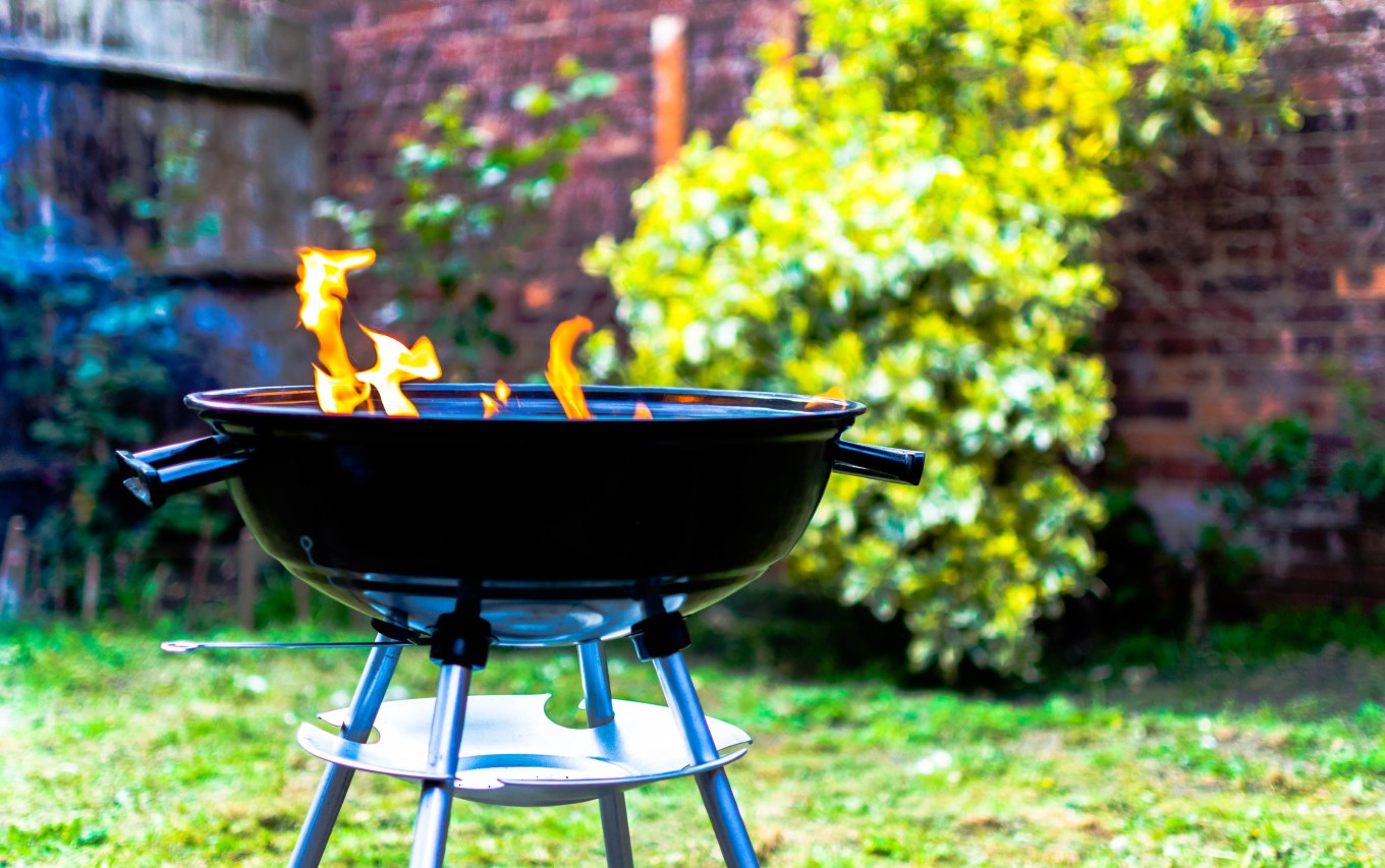 A barbeque grill with flames outside.