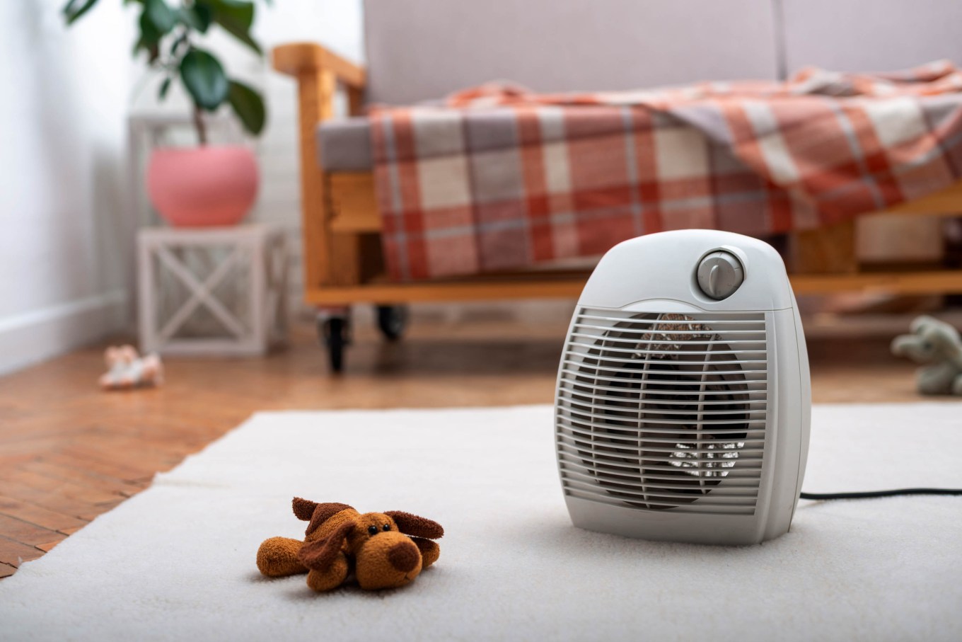 A fan heater on the floor in living room showing a possible firestarter.
