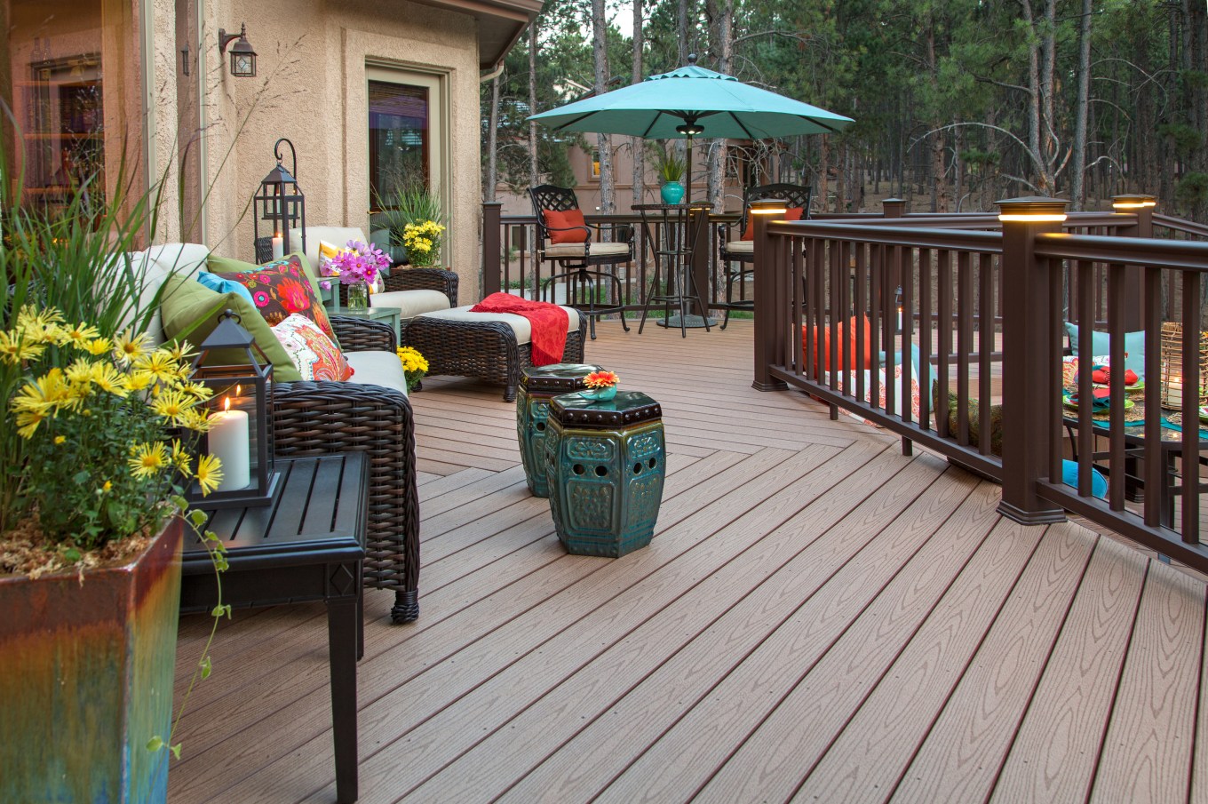 Beautiful composite backyard deck with built-in lighting and fully decorated with vibrant and colorful furniture and decor