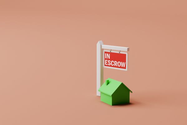 A graphic of a green house with an oversized sign reading "in escrow"