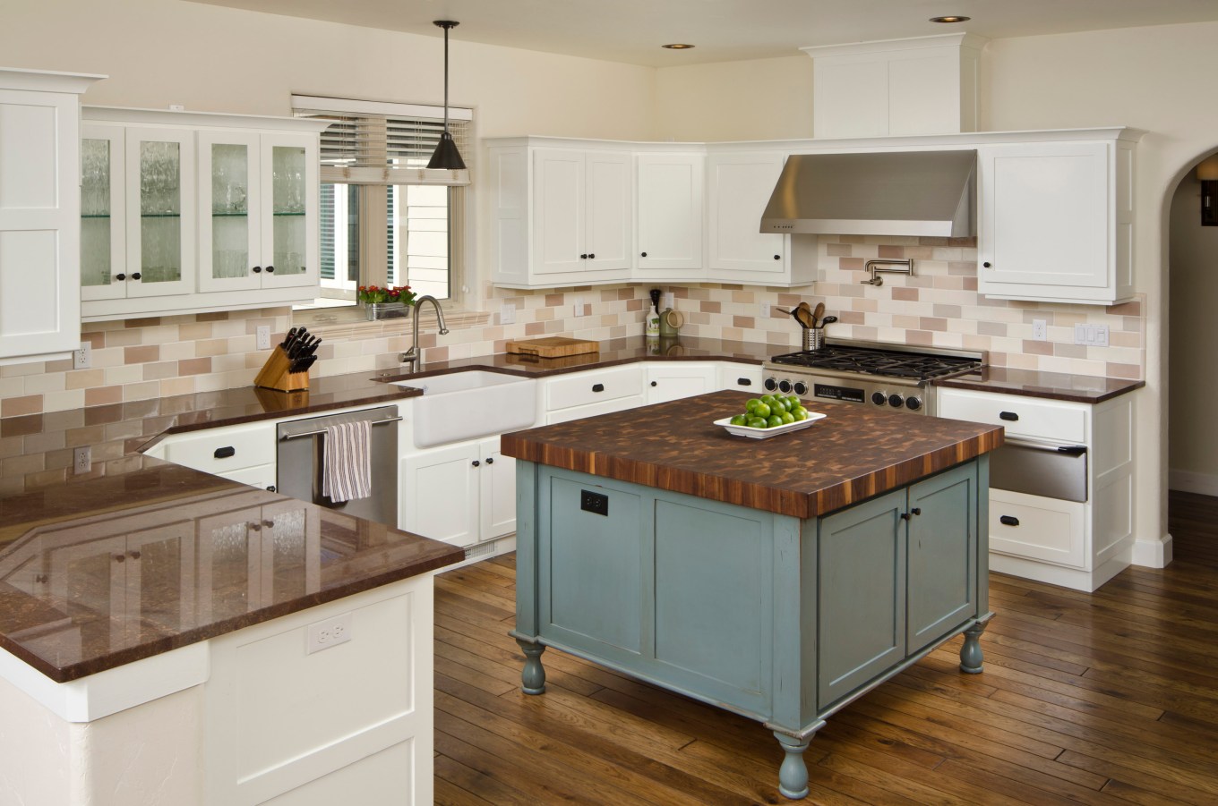 This modern kitchen has white cabinets and blue island.